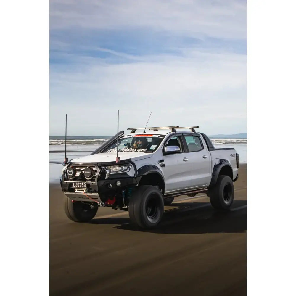 Modified white pickup truck with Rockarmor GT Steel Hoop Bullbar, driving lights, and fog lights