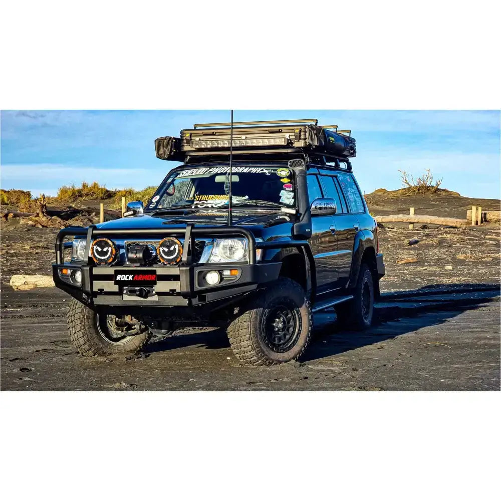 Black off-road vehicle with roof rack featuring Rockarmor Brushbar for Nissan Patrol GU1