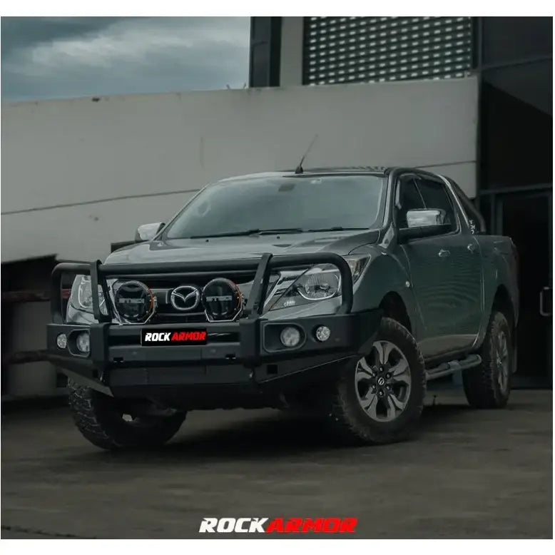 Gray mazda bt-50 pickup truck equipped with rockarmor elite steel hoop bullbar with winch compatible fog lights