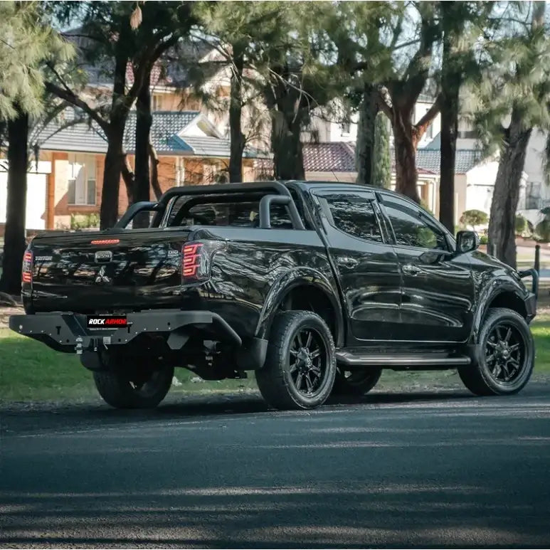Black pickup truck rear showing rockarmor elite steel rear step and elite rear tow bar for mitsubishi triton mq 2015-2018
