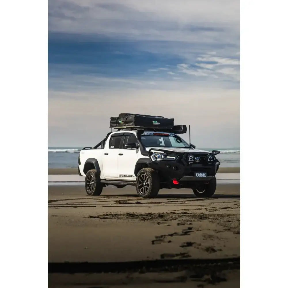 White Toyota Hilux pickup truck with rockarmor gt steel hoop bullbar combo pack and roof tent from 2020 to 2025 models