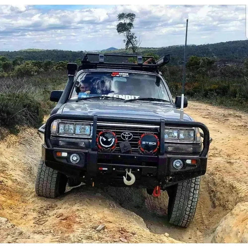Black off-road Toyota Landcruiser Fj80 equipped with Rockarmor premium steel bullbar and integrated LED fog lights