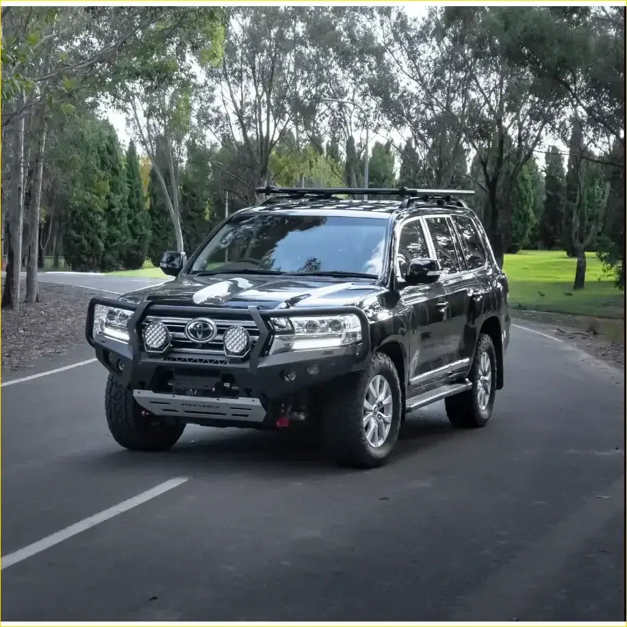 Black toyota land cruiser 300 with rockarmor gt hoop bullbar and rock sliders rugged front bumper and roof rack