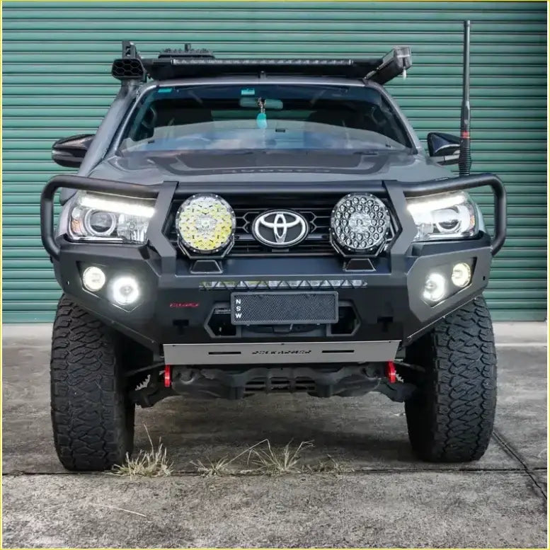 Black toyota tacoma with heavy-duty front bumper and two led light pods in rockarmor rock pack bullbar and rock sliders