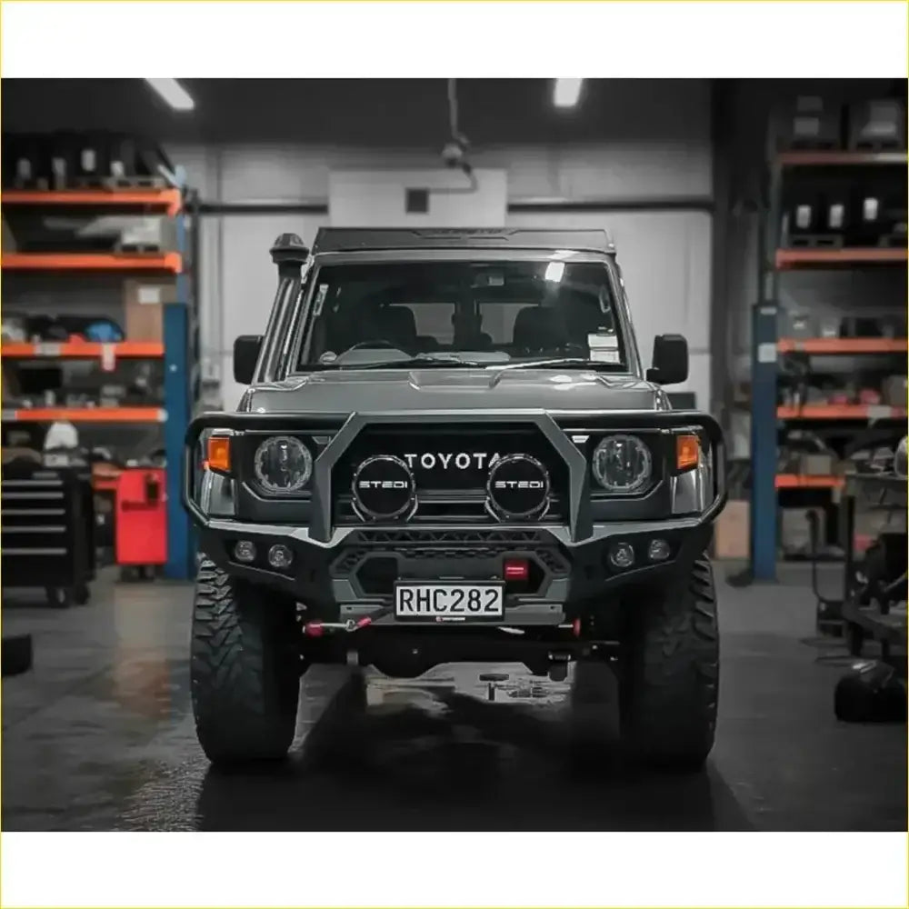 Dark gray toyota land cruiser 70 with rugged gt hoop bullbar and rock sliders from rockarmor rock pack 2023+