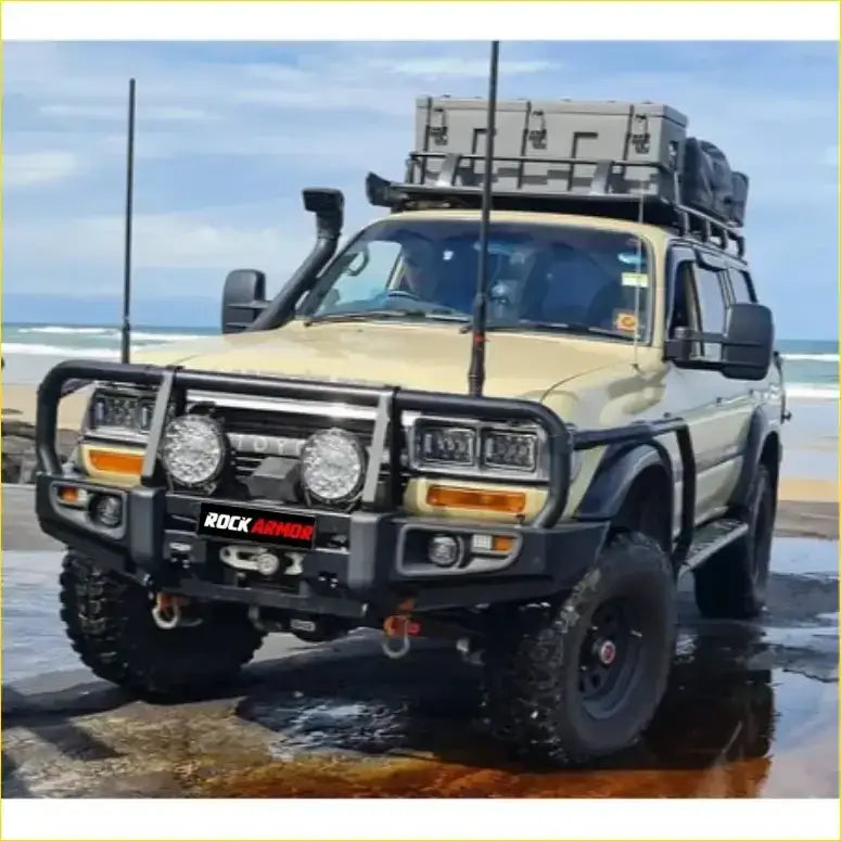 Beige toyota landcruiser fj80 1992-1997 with black rockarmor rock pack bullbar roof rack and auxiliary lights