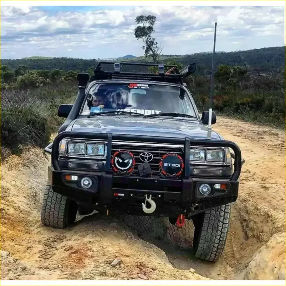 Black toyota landcruiser fj80 with rugged rockarmor rock pack bullbar and rock sliders for off-road toughness