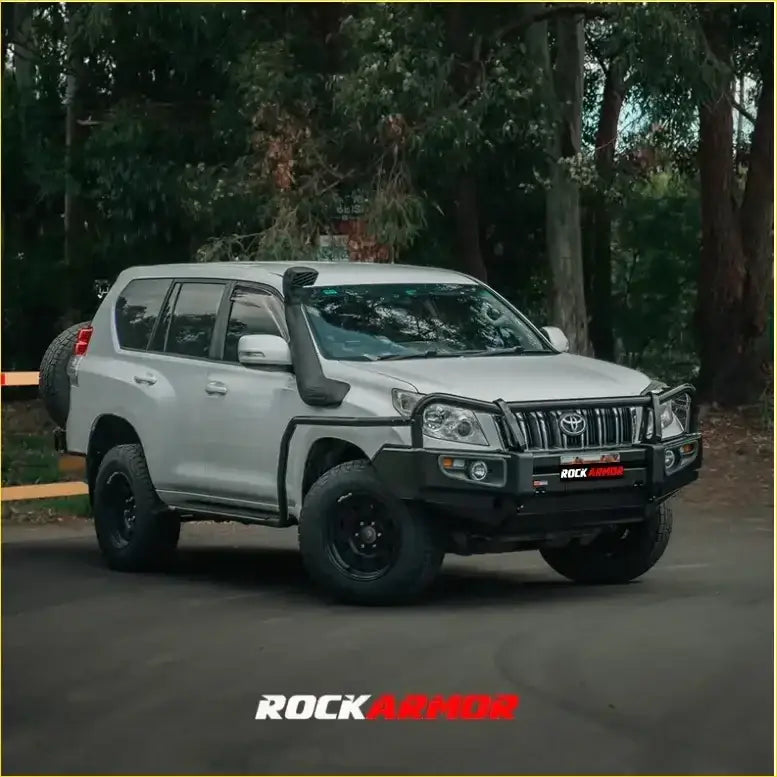 Silver toyota land cruiser prado with black rockarmor front bumper and off-road rock sliders from rock pack