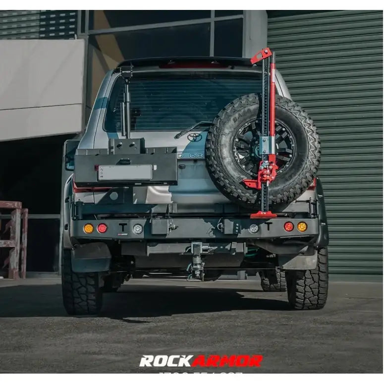 Rear view of silver toyota landcruiser fj105 with rockarmor steel dual wheel carrier and rear-mounted spare tire jack