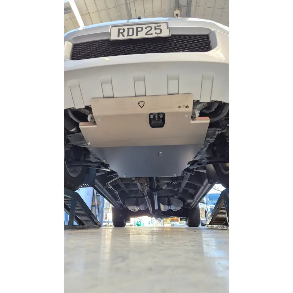 Close-up of a vehicle's front grille with a visible license plate in an indoor setting.