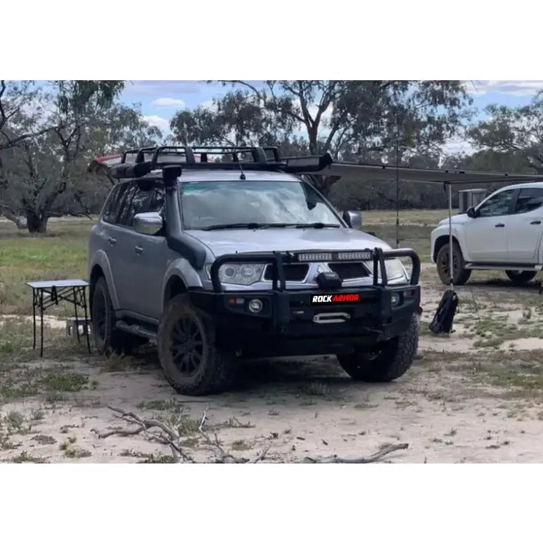 Silver mitsubishi triton challenger with rockarmor premium steel bullbar featuring led fog lights and roof rack