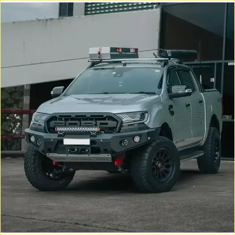 Silver ford ranger wildtrak with black off-road tires featuring rockarmor gt hoopless bullbar and rock sliders