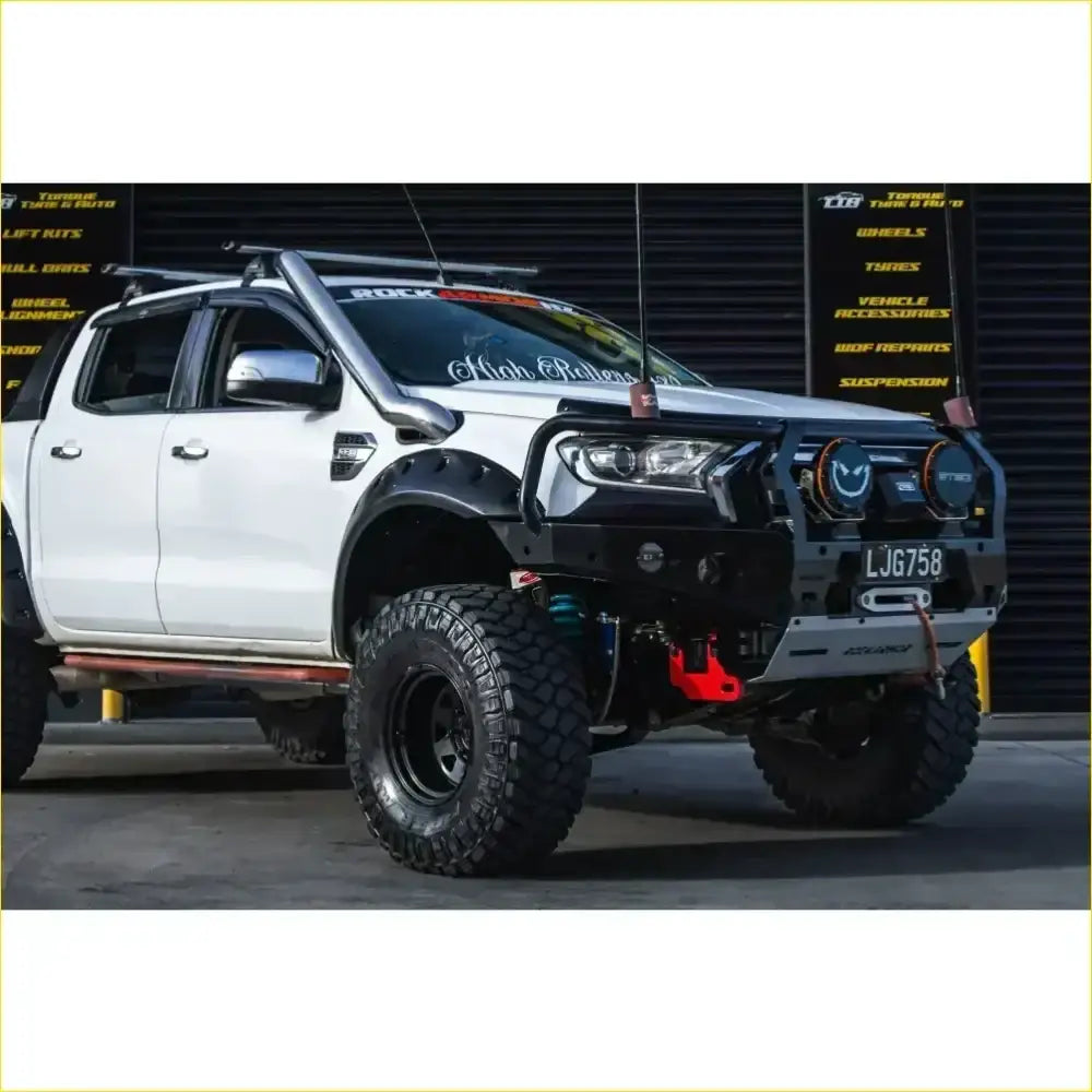Black and silver ford ranger wildtrak off-road truck with gt hoop bullbar rugged tires and rock sliders