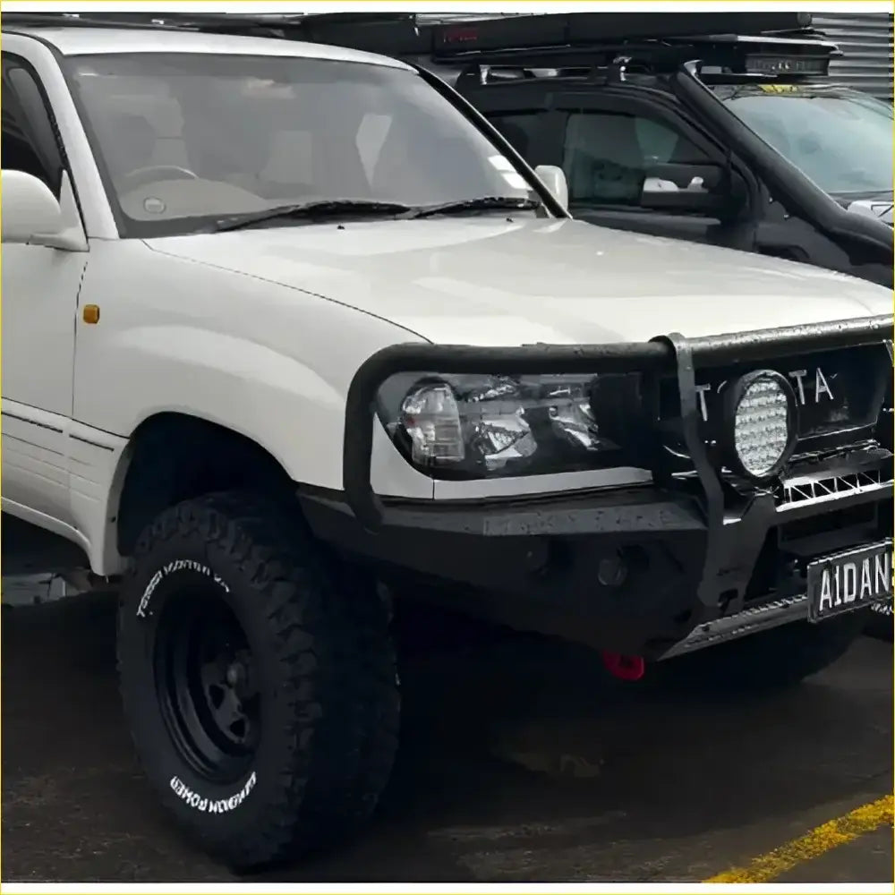 White toyota land cruiser with black gt hoop bullbar and rock sliders from rockarmor rock pack 100 series