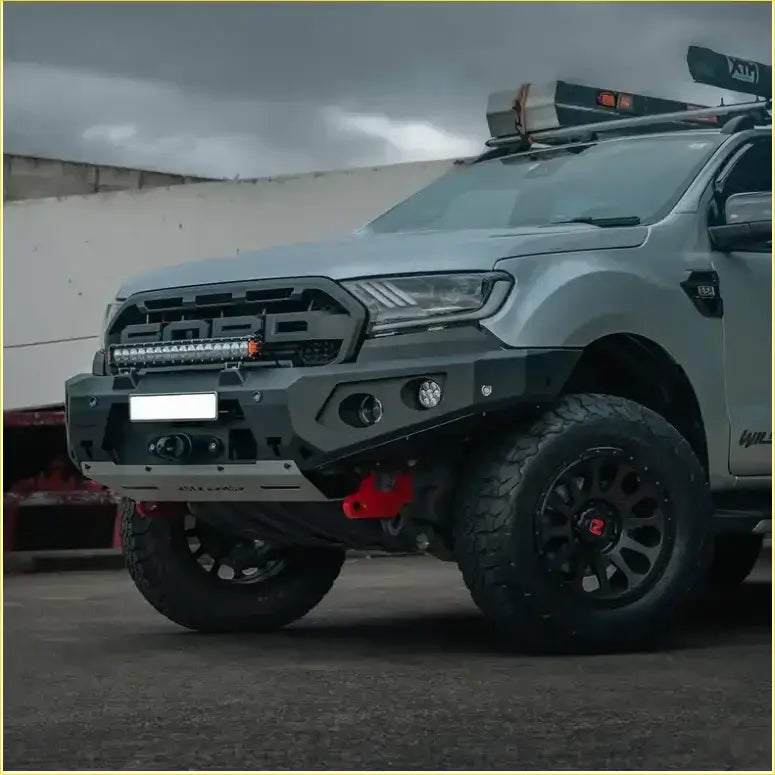 Gray ford ranger with rugged black off-road tires roof rack and rockarmor gt hoopless bullbar rock sliders