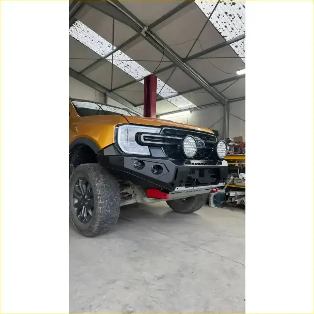 Black rugged front bumper with led lights and red tow hooks on yellow ford ranger from rockarmor rock pack