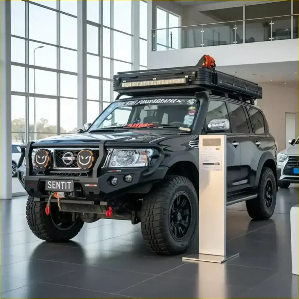 Black nissan patrol gu4 with rockarmor rock pack featuring gt hoop bullbar rock sliders rugged tires and roof rack gear