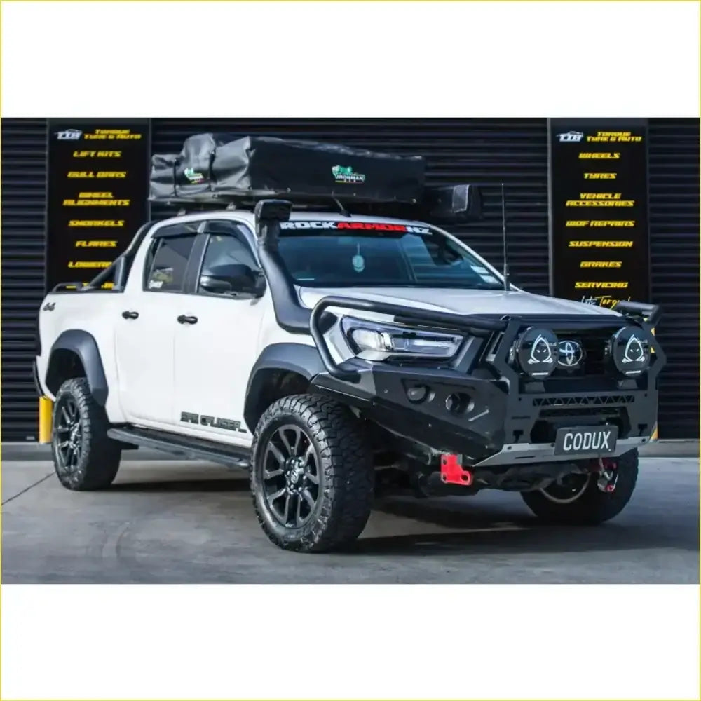 White toyota hilux 2022 widebody with black gt hoop bullbar roof rack and rock sliders off-road accessories
