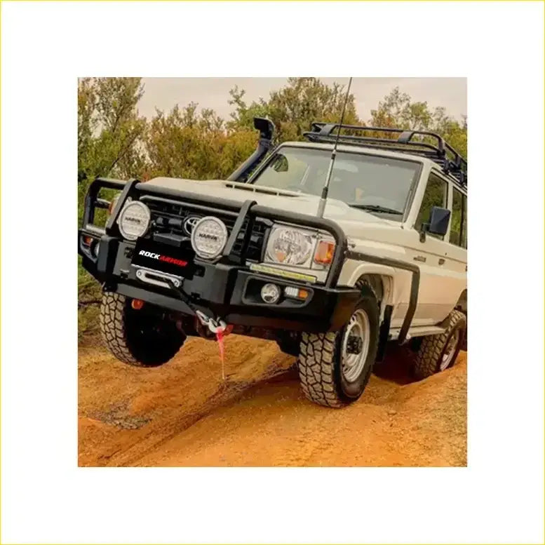 Black rock autoguard front bumper with round headlights and winch hook on white toyota land cruiser rockarmor rock pack
