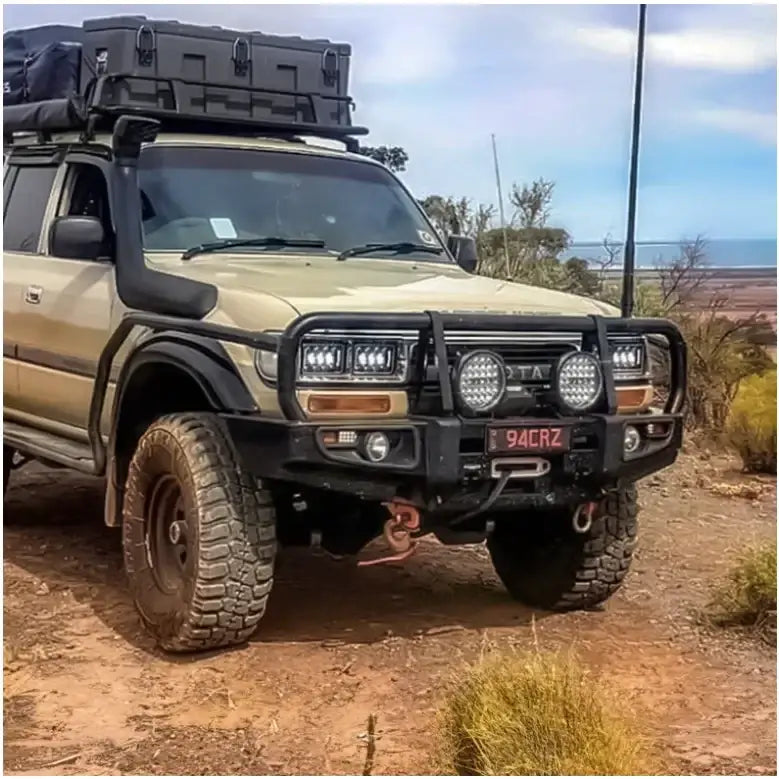 Modified tan toyota landcruiser fj80 with black rockarmor steel rockslider checker plate step on the side
